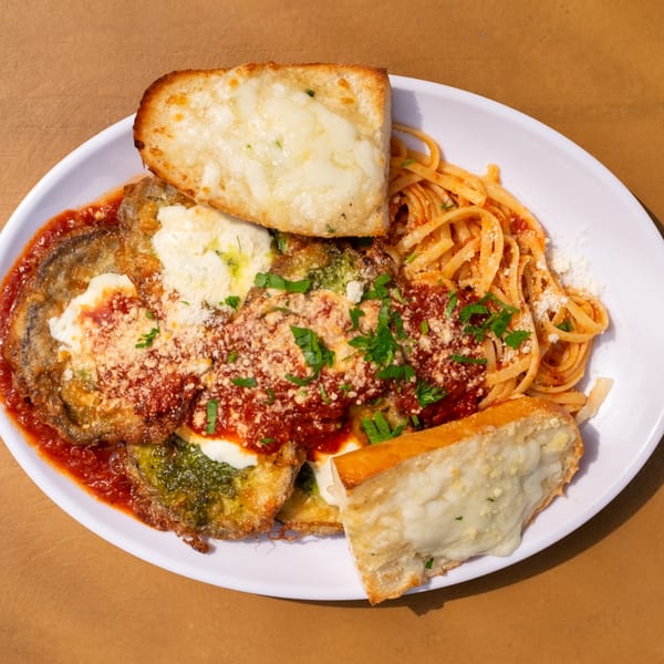 Tardino Brother's eggplant parmesan with linguine, marinara sauce, and two slices of cheesy garlic bread.
